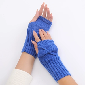 Detail of dark blue knit fingerless gloves with bow decoration and thumb hole design