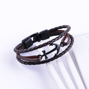 Detail view of multi-layer brown leather bracelet with black anchor charm and magnetic clasp