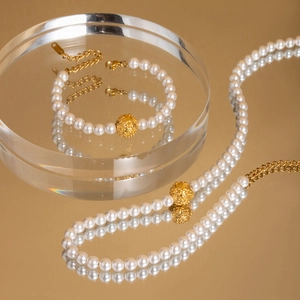 Elegant pearl jewelry set with necklace, bracelet and golden textured metal ball