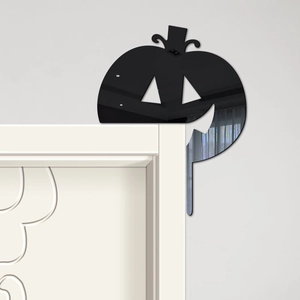 Detailed view of a black acrylic pumpkin mirror sticker on a white door frame corner