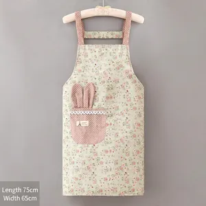 Detail of light green floral apron featuring a pink dotted pocket with rabbit ears and lace