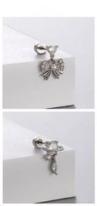 Detail of silver titanium heart bow and planetary teardrop zircon drop earrings