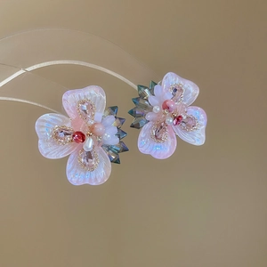Macro shot of silver needle flower earrings with sparkling crystals and faux pearls