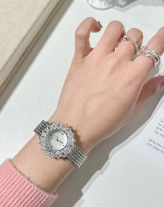 Dettaglio orologio donna elegante con castone di strass e cinturino a maglia intrecciata