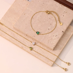 Elegant gold stainless steel bracelet set featuring green and clear heart shaped crystals