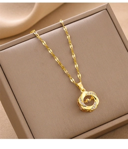 Close-up of a gold-plated necklace with a crystal-encrusted hollow pendant on a jewelry box