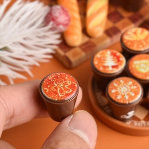 Macro view of miniature Christmas latte coffee cups with gingerbread man resin patterns