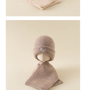 Detail of knitted baby hat and scarf set with heart embroidery in oatmeal beige