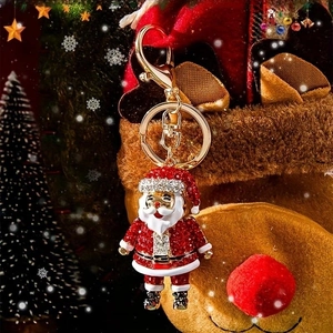 Close-up of sparkling Santa Claus keychain with red rhinestones and golden hardware