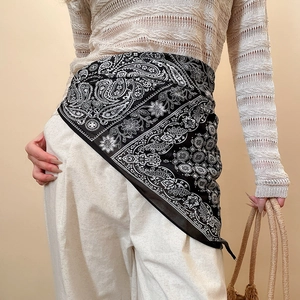 Detail of a paisley print silk scarf used as a stylish waist accessory for women
