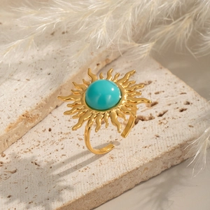 Vintage sun shaped gold ring with turquoise stone on stone background for women