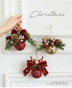 Close-up of Christmas bell ornaments with pine cones, red berries and velvet bows