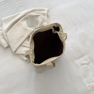 Macro view of the large capacity beige corduroy tote bag showing brown lining and interior