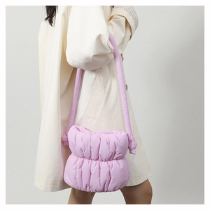 Side view of soft pink quilted puffer shoulder bag showing puffy nylon fabric texture