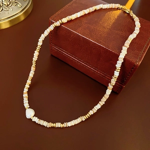 Detail of 14K gold plated necklace with shell pearls on a vintage brown leather box