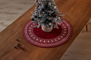Detail of red knit Christmas tree skirt featuring white snowflake and tree patterns