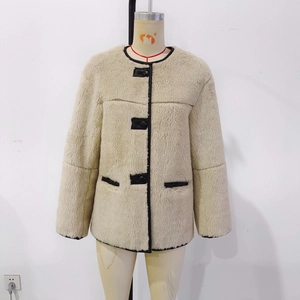 Detail of faux fur jacket with black leather trim, round neck, and contrast buttons