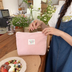 Pink corduroy makeup bag detail featuring sozakka beauté label and zipper closure