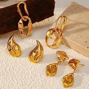 Detail of three pairs of gold stainless steel earrings in drop and chain styles
