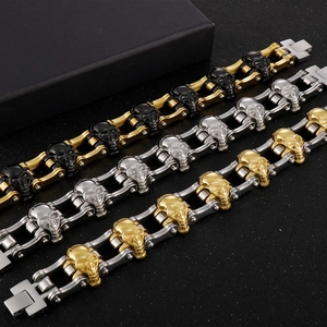 Three punk skull bracelets in gold, silver, and black finishes on a textured dark background