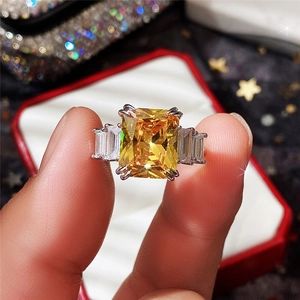 Detailed macro shot of rectangular yellow gemstone ring with silver trapezoid side stones