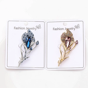 Close-up of feather brooches with blue and pink crystals on premium alloy metal
