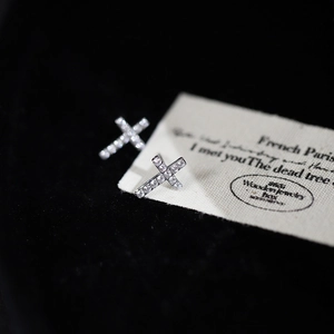 Exquisite silver cross stud earrings with micro-set zircon on black velvet background
