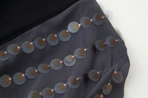 Macro view of gray sequins and fine stitching on a long sleeve V-neck jumpsuit