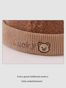 Detailed view of lucky bear embroidery on brown sherpa fleece and corduroy kids hat