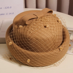 French vintage camel wool beret with mesh veil and bow detail in an elegant setting