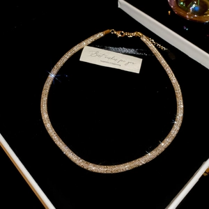 Detail of champagne gold rhinestone mesh necklace on black velvet with gift card