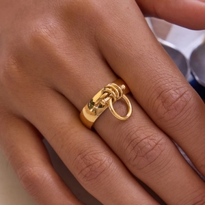 Close-up of a gold-plated stainless steel ring with equestrian chain and hook design