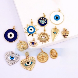 Detailed view of micro-pave evil eye charms in gold-plated copper and blue enamel