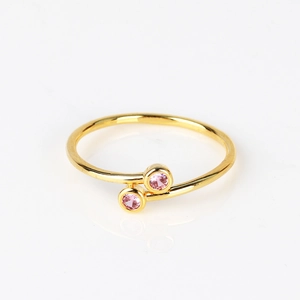 Macro detail of 18K gold-plated spiral ring with two round pink cubic zirconia stones