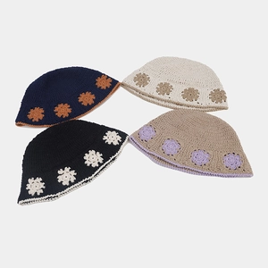Flat lay of four colorful crochet bucket hats with floral patterns and contrast edges