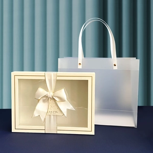 Detail of cream gift box with ribbon and matching translucent frosted handle bag