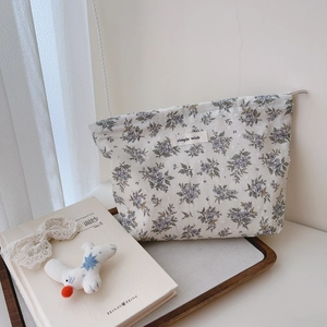 Detailed view of floral cotton makeup bag with 'simple wish' label on wooden tray