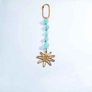 Detailed shot of celestial sun charm featuring sky blue beads and golden metal sun pendant
