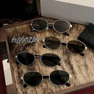 Vintage oval metal sunglasses with nylon lenses in multiple colors on a textured tray