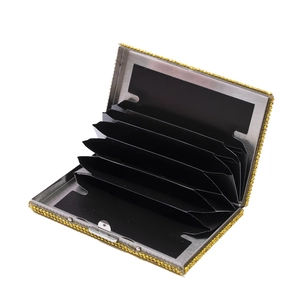 Golden rhinestone card holder with black accordion slots and shiny metallic finish
