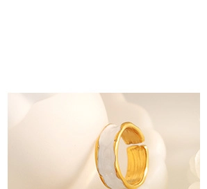 Macro shot of 18K gold plated C-shape ring with white enamel and hand-crafted fluid design
