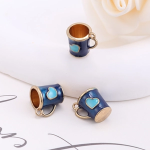 Detailed view of three blue enamel mini mug charms with gold accents and heart patterns