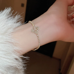 Gros plan du bracelet trèfle plaqué or avec oxydes de zirconium sur le poignet