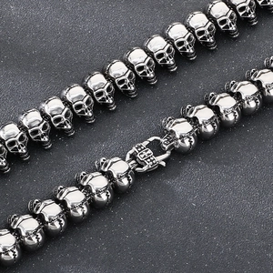 Macro detail of gothic skull beads and cross lobster clasp on stainless steel chain