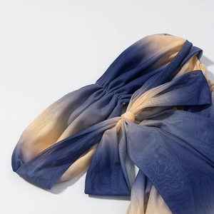 Detailed macro view of the blue and beige gradient mesh fabric with elegant pleats