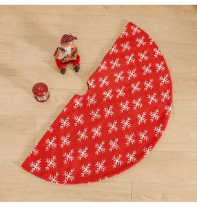 Close-up of red Christmas tree skirt with white snowflake jacquard on wood floor