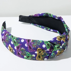Detail of purple Mardi Gras headband featuring carnival mask prints and white polka dots