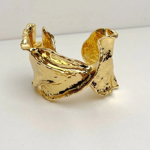 Minimalist gold cuff bracelet with irregular crumpled texture and a wide open design