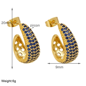 Detail showing 20mm gold C-shape hoop earrings with micro-pave blue zircon stones
