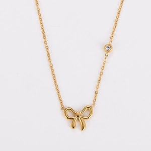Detailed view of gold bow pendant necklace with a sparkling inset crystal accent